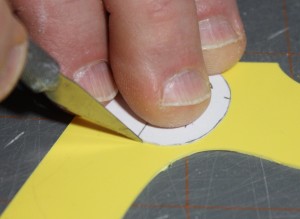 Scoring around paper template making sure there is no shift while cutting